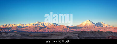 Panorama of Moon Valley in Atacama desert at sunset, snowy Andes mountain range in the background, Chile Stock Photo