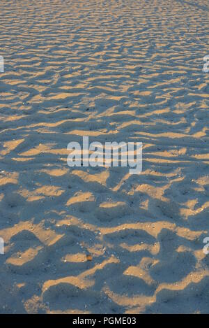 Yellow sand of the black sea at sunset with a blue shadow and golden color, very ordinary background. Stock Photo