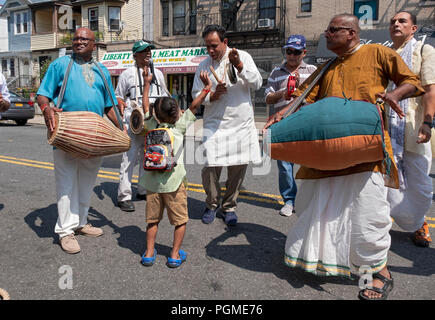 A young Hindu girl dances gleefully while musicians play before the 2018 Queens, New York rathayatra Parade.