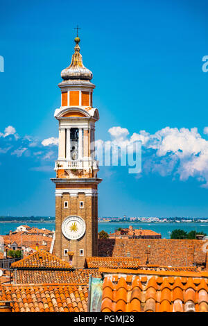 A brick bell tower (Campanile) adorned with a beautiful clock from the Chiesa Cattolica Parrocchiale dei Santi Apostoli church in Venice, Italy Stock Photo