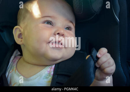 Beautiful baby in baby seat in the car having a pleasant trip Stock Photo