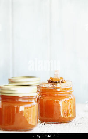 A row of mason jars full of homemade Cantaloupe Jam against a rustic background. Extreme shallow depth of field with selective focus on center jar. Im Stock Photo