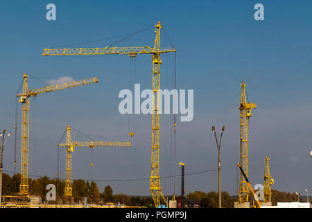 yellow cranes on construction site against the sky Stock Photo