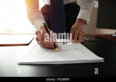 Businessman analyzing investment charts. Hands of financial manager taking notes when working Stock Photo