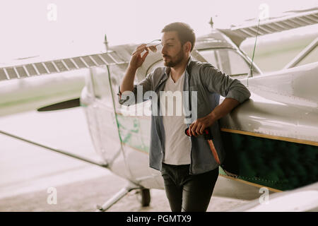 Handsome young pilot checking ultralight airplane before flight Stock Photo