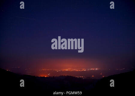 Streetlights of Ruthin at night glowing through fog in the Vale of Clwyd, North Wales Stock Photo