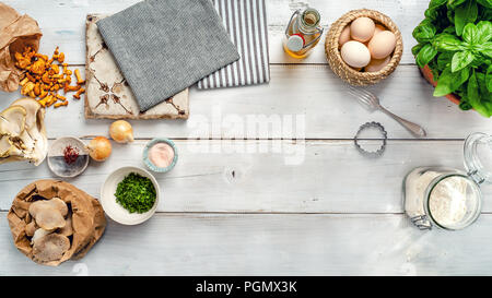 Food ingredients for the preparation of Pasta with mushroom filling on white wood panelling. Food background with copy space. Flat lay, top view. Stock Photo