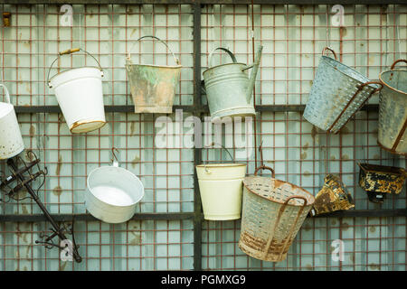 Variety of buckets hanging up for sale in a junk shop Stock Photo