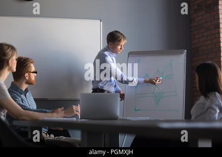 Male speaker giving flipchart presentation to colleagues Stock Photo