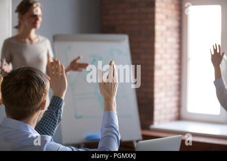 People raising hands brainstorming at office training Stock Photo