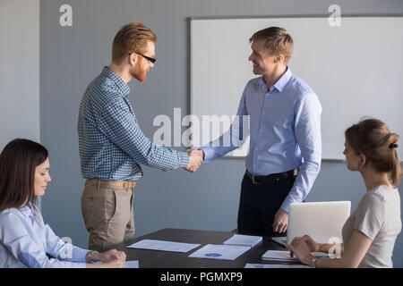 Smiling businessman handshake male worker congratulating with su Stock Photo