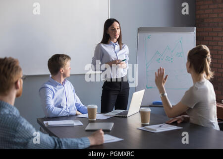 Female employee asking question to business speaker during metin Stock Photo