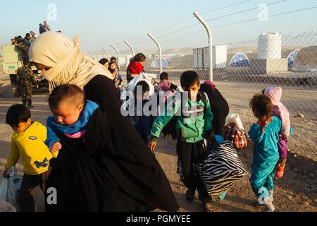 A refugee camp in Iraq, where live people escaped from ISIS. A woman with her children just arrived at the camp.