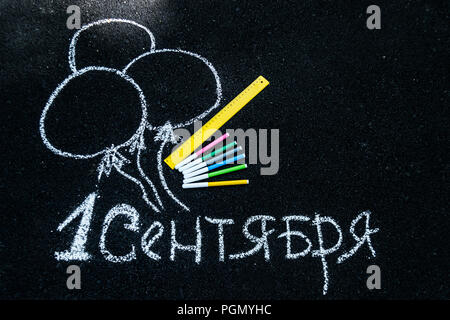 white chalk on black asphalt inscription in Russian September 1. yellow line, colorful markers, painted balls Stock Photo