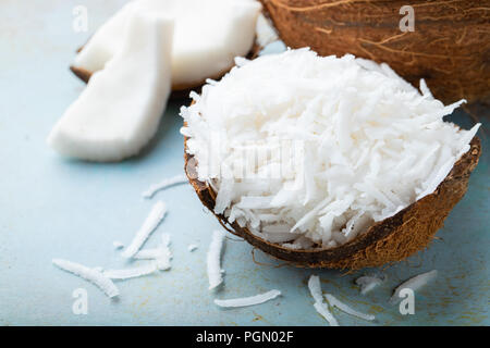 Coconut flakes in a shell on a blue background. Stock Photo