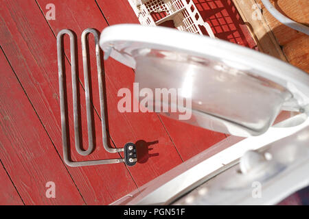 damaged washing machine heating element on the foor, above view Stock Photo