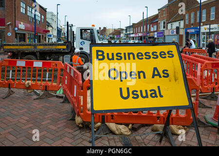 Business as usual sign in a pedestrianised High Street blocked by major road works Stock Photo