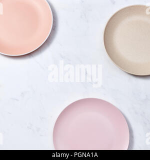 Traditional decorative ceramic handcraft plates covered with glazed on a gray background. Flat lay Stock Photo