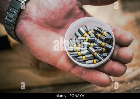 Screwdriver Bits in Hand of Construction Worker. Closeup Photo. Stock Photo