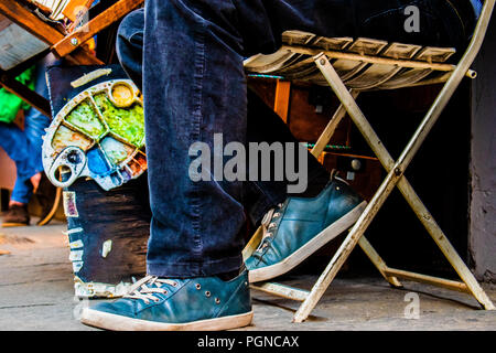 Street artist sitting on a chair with color palette Stock Photo