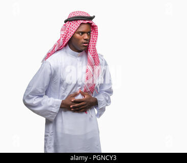 Young arabic african man wearing traditional keffiyeh over isolated background with hand on stomach because indigestion, painful illness feeling unwel Stock Photo