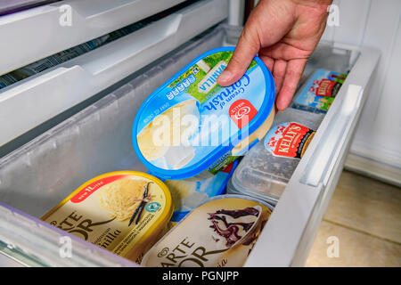 Mans hand getting out an ice cream tub from a home freezer Stock Photo