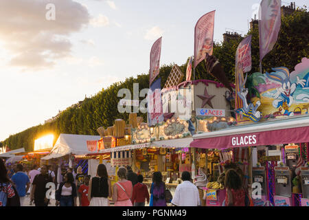 People walking along the Tuileries funfair in the early evening in Paris, France. Stock Photo