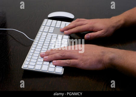 Typing Hands using Arrow Keys on Desk with Mouse and Keyboard Stock Photo