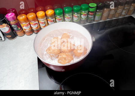 Six eggs boiling in a saucepan on an Induction Hob Stock Photo