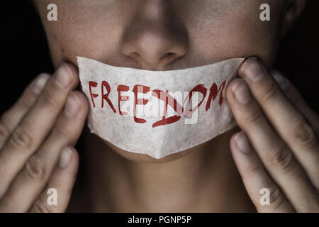 Concept on the topic of freedom of speech: the girl's face is sealed with scotch tape Stock Photo
