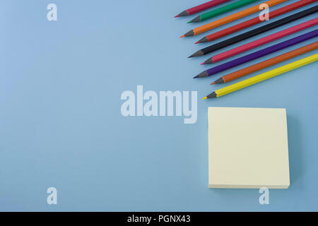 Calendar and colorful pencils isolated in angle on pastel blue background table. Space for text, flat lay style. Stock Photo