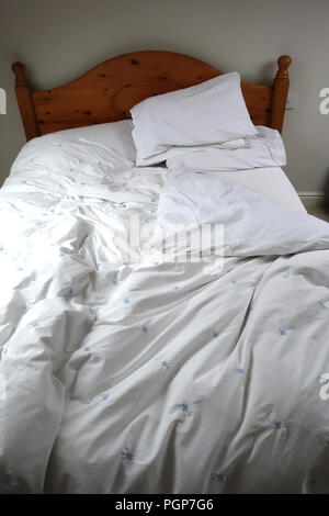 Egyptian cotton bedding on comfortable bed in a cottage guest bedroom Stock Photo