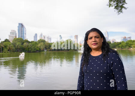 Portrait of mature Indian woman relaxing at the park Stock Photo