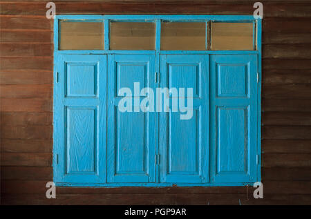 light blue painted vintage retro wooden windows and panes, home interior architectural design against plain tropical dark brown textured wood panel bo Stock Photo