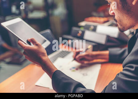 Businessmen are analyzed data from report using smartphone and laptop computer. Stock Photo