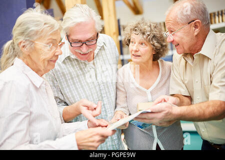 Senior group enjoys reading and learning with books in the library Stock Photo