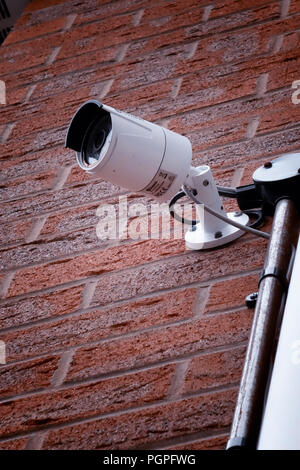 Security surveillance camera lens isolated high on a wall of a private house in Rotherham, South Yorkshire, England. Stock Photo