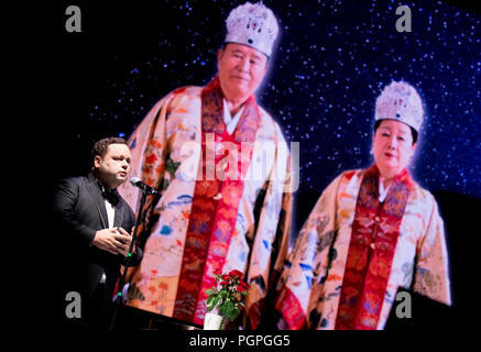 Seoul, South Korea. 27th Aug 2018. Paul Potts, Aug 27, 2018 : British tenor Paul Potts performs as a picture of Hak Ja Han Moon (R), wife of the late Reverend Sun Myung Moon and Moon is seen on a screen during a mass wedding ceremony of the Unification Church at the CheongShim Peace World Center in Gapyeong, about 60 km (37 miles) northeast of Seoul, South Korea. Four thousand newlywed couples from around the world participated in the mass wedding on Monday, which was organized by Hak Ja Han Moon, wife of the late Reverend Moon. Credit: Aflo Co. Ltd./Alamy Live News Stock Photo