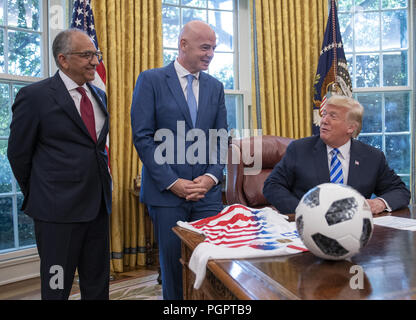 Washington, District of Columbia, USA. 28th Aug, 2018. United States President Donald J. Trump, right, meets with Gianni Infantino, center, President of Fédération Internationale de Football Association (FIFA) in the Oval Office of the White House in Washington, DC on Tuesday, August 28, 2018. FIFA describes itself as an international governing body of association football, futsal, and beach soccer. Looking on at left is US Soccer President Carlos Cordeiro Credit: Ron Sachs/CNP/ZUMA Wire/Alamy Live News Stock Photo