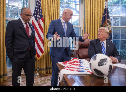 Washington, District of Columbia, USA. 28th Aug, 2018. United States President Donald J. Trump, right, meets with Gianni Infantino, center, President of Fédération Internationale de Football Association (FIFA) in the Oval Office of the White House in Washington, DC on Tuesday, August 28, 2018. FIFA describes itself as an international governing body of association football, futsal, and beach soccer. Looking on at left is US Soccer President Carlos Cordeiro Credit: Ron Sachs/CNP/ZUMA Wire/Alamy Live News Stock Photo