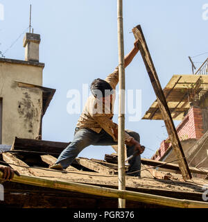 KATMANDU, NEPAL - MAR 6, 2017: Unidentified Chhetri boy repairs the roof. Chhetris is the most populous ethnic group of Nepal Stock Photo