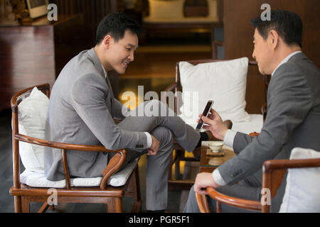 Cheerful businessmen using smart phone Stock Photo