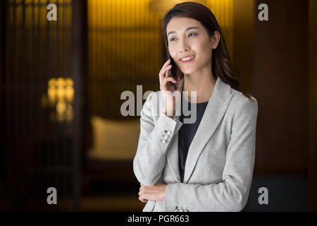 Cheerful young businesswoman talking on cell phone Stock Photo