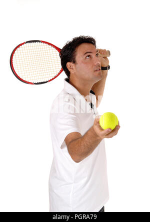 A handsome young man in a white shirt holding his yellow ball ready for a swing with his racket, isolated for white background Stock Photo