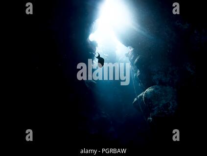 Fish swim through a beautiful underwater coral cave in the Red Sea Stock Photo