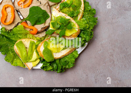 Fresh prepared bread slices or sandwiches with homemade mackerel or tuna fish and pork liver paste, lettuce, parsley, Toasts with avocado paste and or Stock Photo
