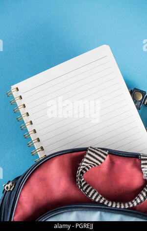 School backpack and notebook on blue background. Stock Photo