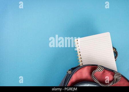 School backpack and notebook on blue background. Stock Photo