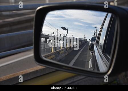 Eurotunnel: a French driver's rear view through the wing mirror boarding a Eurotunnel train to cross under the English Channel, or La Manche Stock Photo