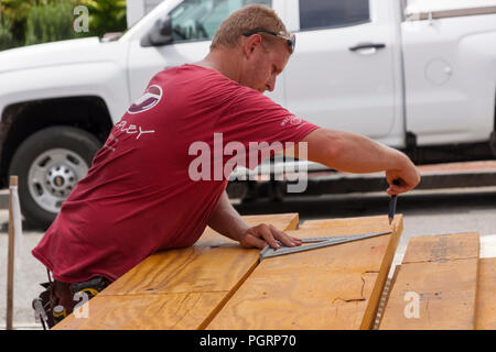 Carpenter using a triangle for precision measuring of a piece of wood. Stock Photo